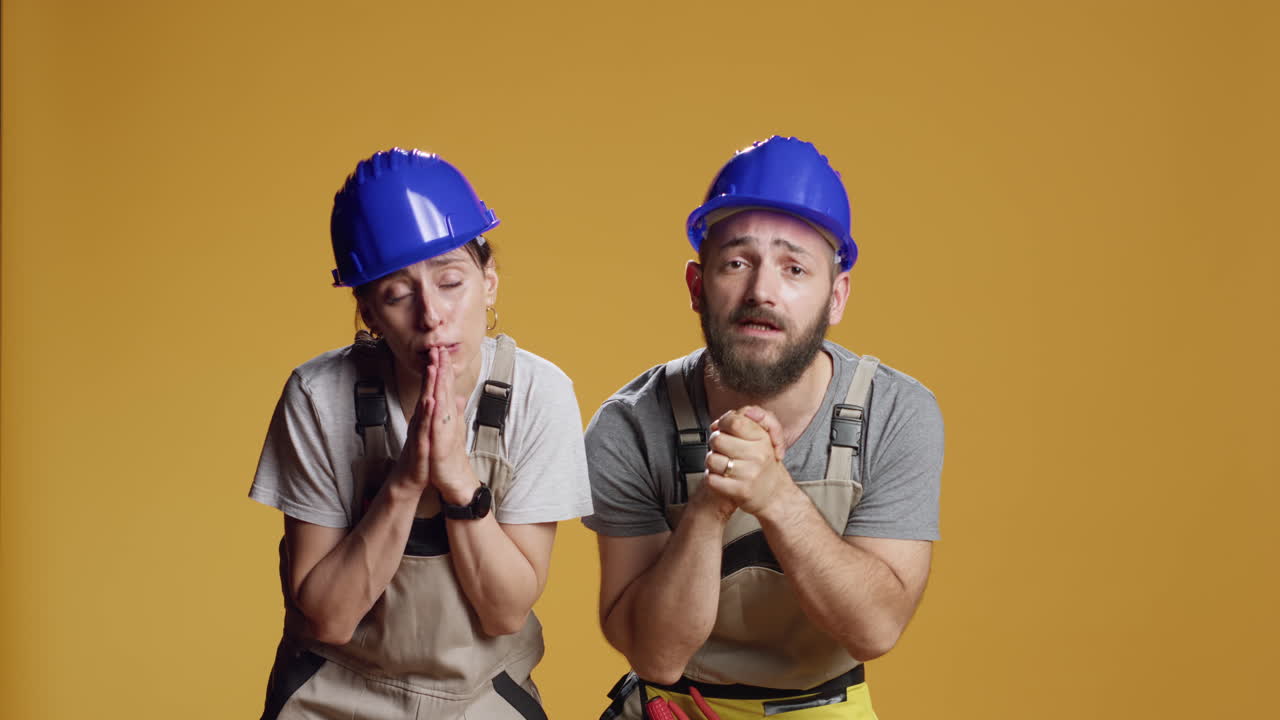 Team of contractors praying to work on building construction site