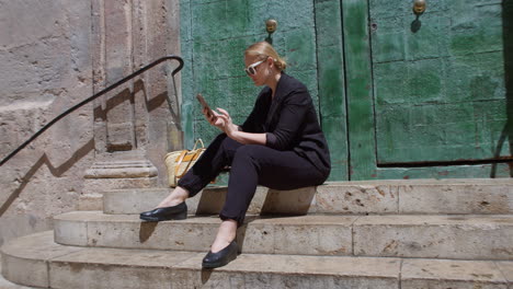 Una-Mujer-Joven-Está-Sentada-Sobre-Escalones-De-Piedra