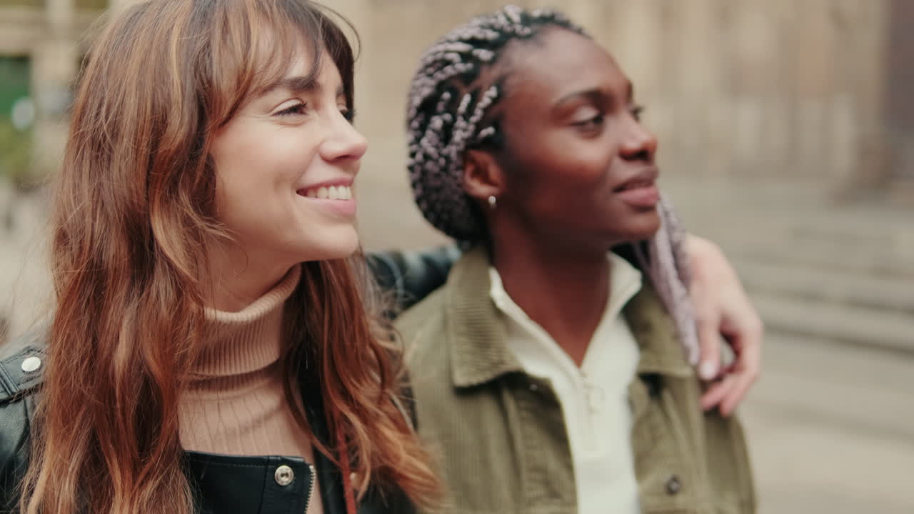 Joyful Young Women Pointing and Laughing on an Urban Street