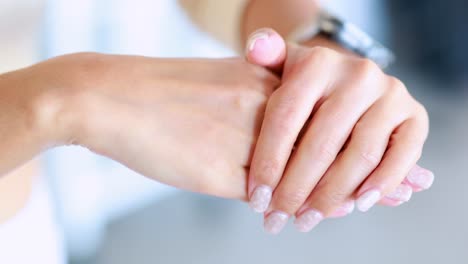 a person dispenses and rubs hand cream onto their skin in a well-lit, modern indoor setting. close-up shots emphasize smooth, careful application