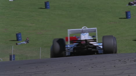 two race cars head into a turn on a track