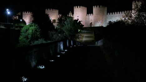 a nocturnal view of avila's old town and the illuminated, unesco-protected medieval walls in spain.