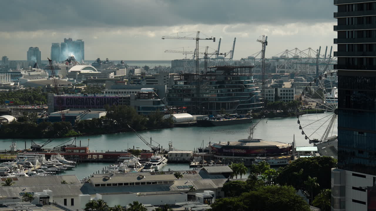 Vista del lungomare di Miami che mostra il porto turistico, le gru edili e gli edifici moderni lungo la baia, evidenziando la crescita urbana attiva, l'espansione delle infrastrutture e lo sviluppo costiero