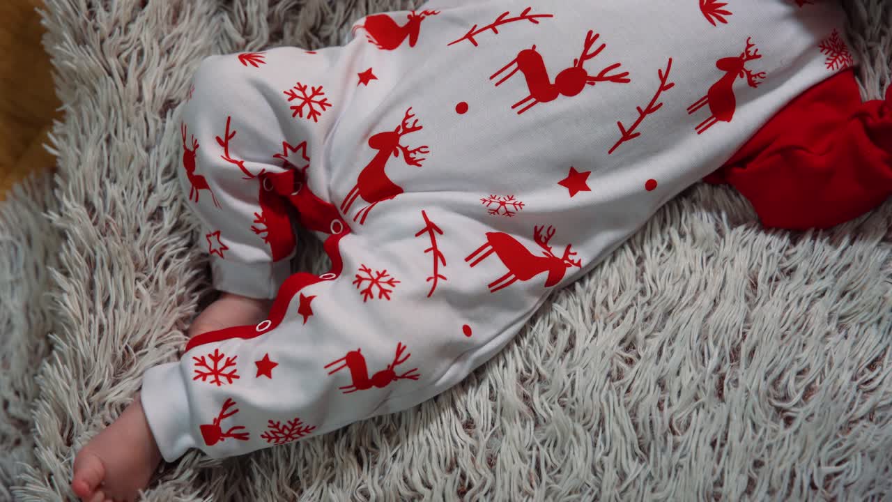 filmando desde arriba los pequeños pies descalzos y los dedos de los pies del bebé con ropa de año nuevo