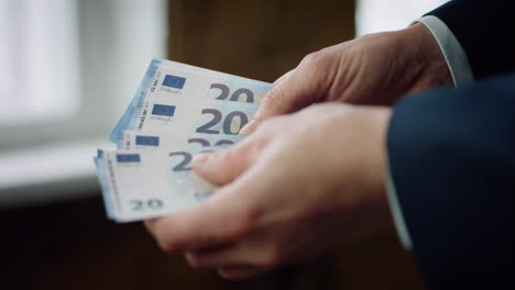 man counting twenty euros close up. bankrupt businessman calculating money cash.