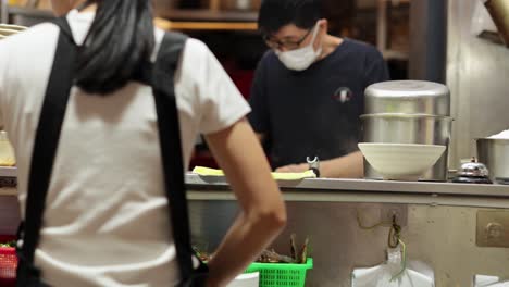 chef cooking with mask in bustling kitchen