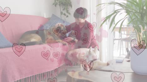 animation of heart emojis over happy caucasian woman with dogs
