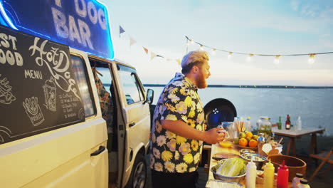 hombre alegre vendiendo comida a la gente en el festival de verano