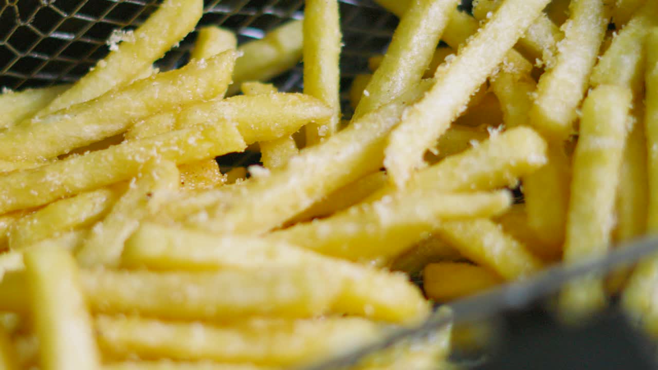 Freshly Fried French Fries in Deep Fat Fryer Basket Ready to Serve After Cooking in Hot Oil. Unhealthy Crispy Chips Fast Food