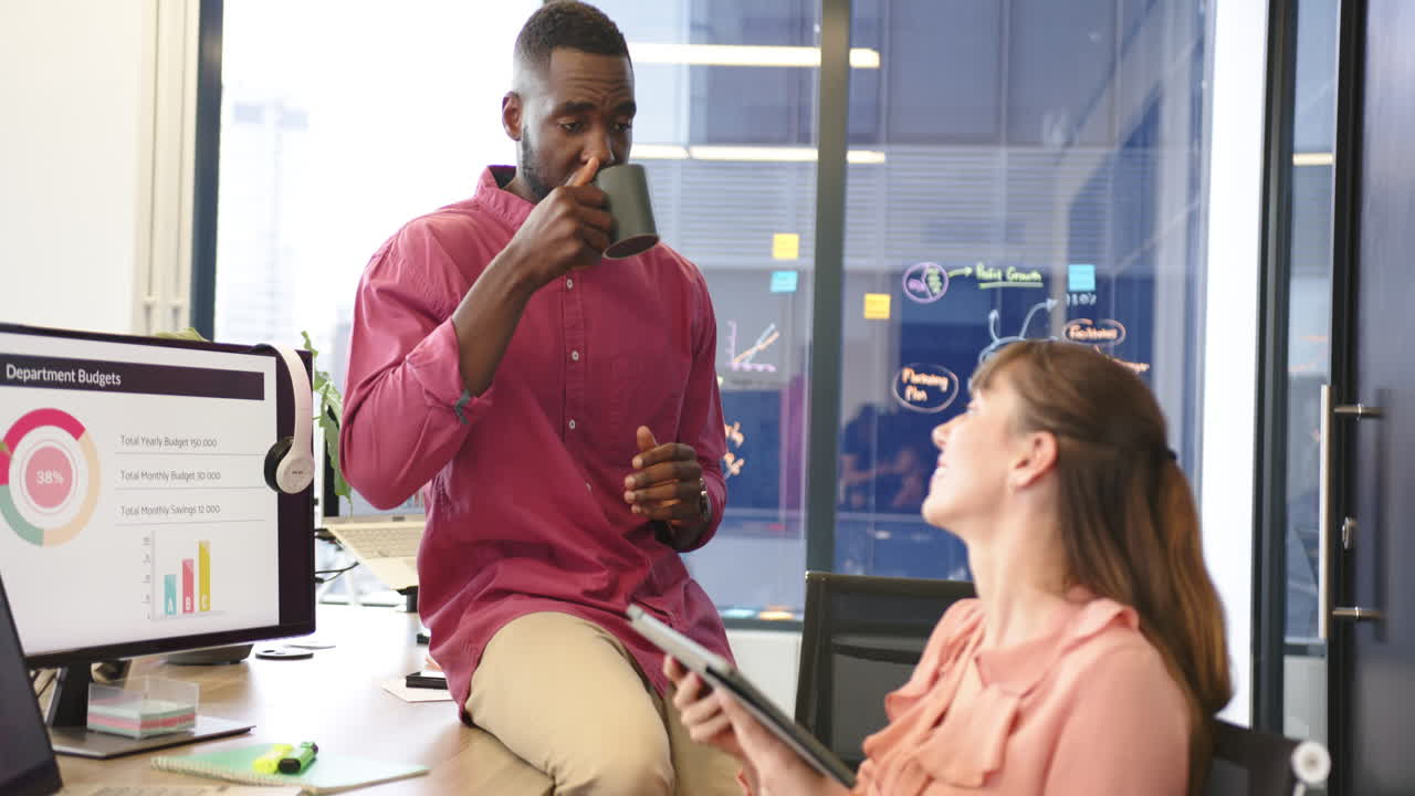 Talking on smartphone, man sitting in office with presentation screen in background