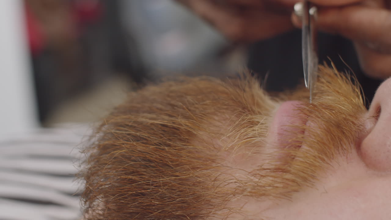 이발사 가 가위 를 사용 하여 남성 고객 의  ⁇ 수염 을 자르고 있다