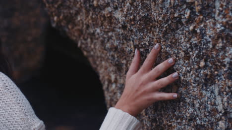 Nahaufnahme-Einer-Frau-Mit-Der-Hand,-Die-Felsen-Berührt,-Die-Küste-Erkundet-Und-Abenteuer-Genießt