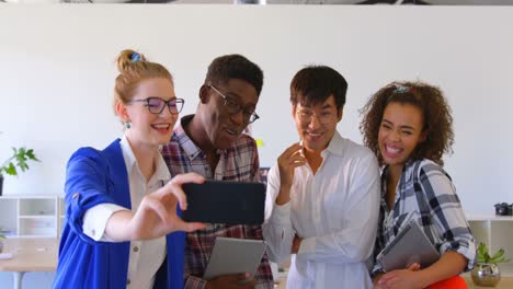 jóvenes colegas de negocios multiétnicos tomando selfies con teléfonos móviles en una oficina moderna 4k