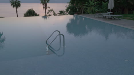 Una-Toma-De-Steadicam-De-Una-Piscina-Abierta-Vacía-Con-Una-Barandilla-De-Metal