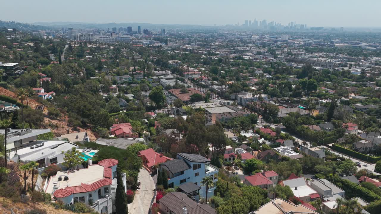 Low reverse pullback aerial shot of Los Angeles from Hollywood Hills in Southern California. 4K