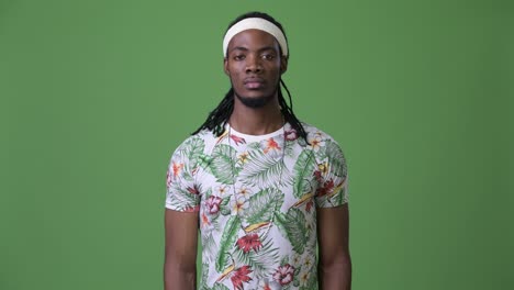 young handsome african man with dreadlocks against green background