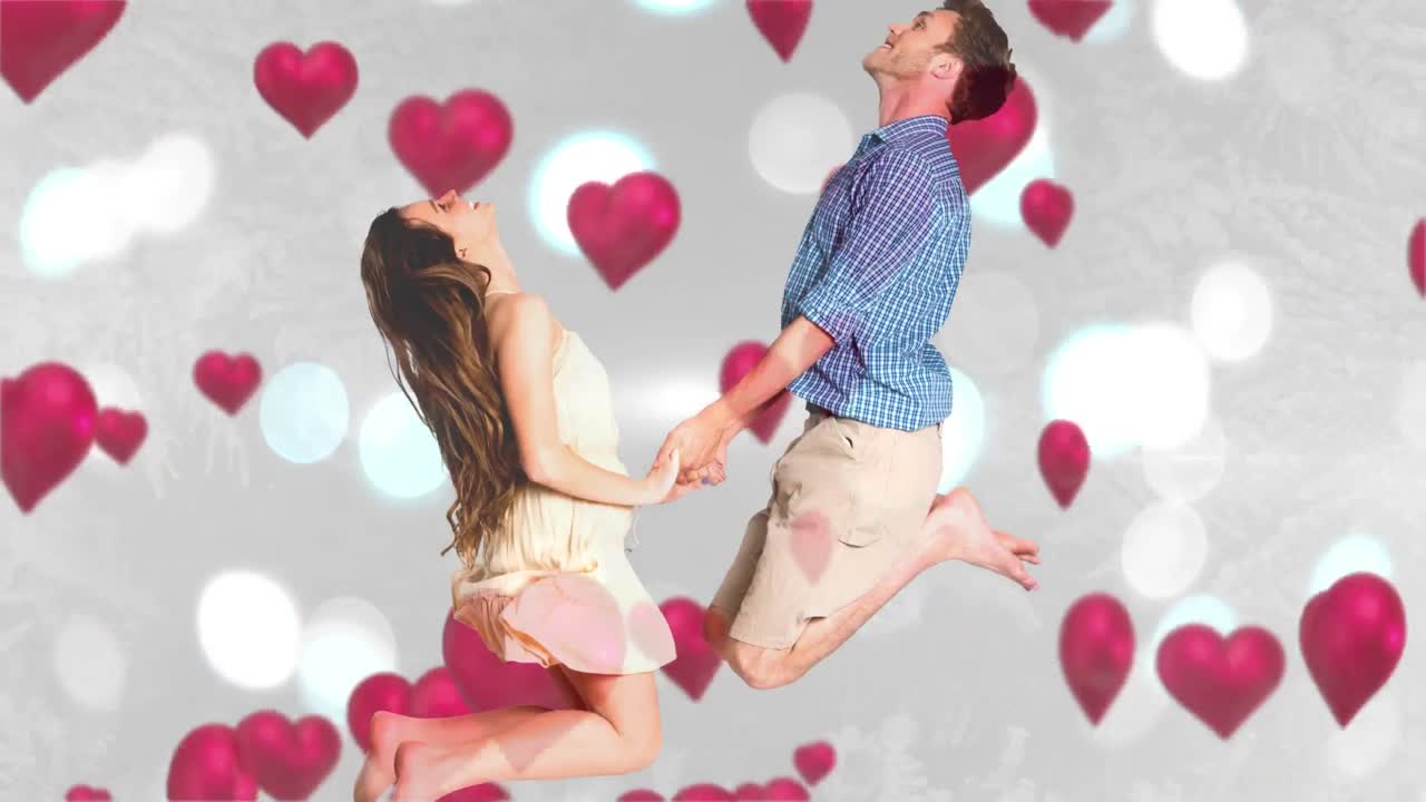 행복한 커플이 손을 잡고 점프하고 있습니다.