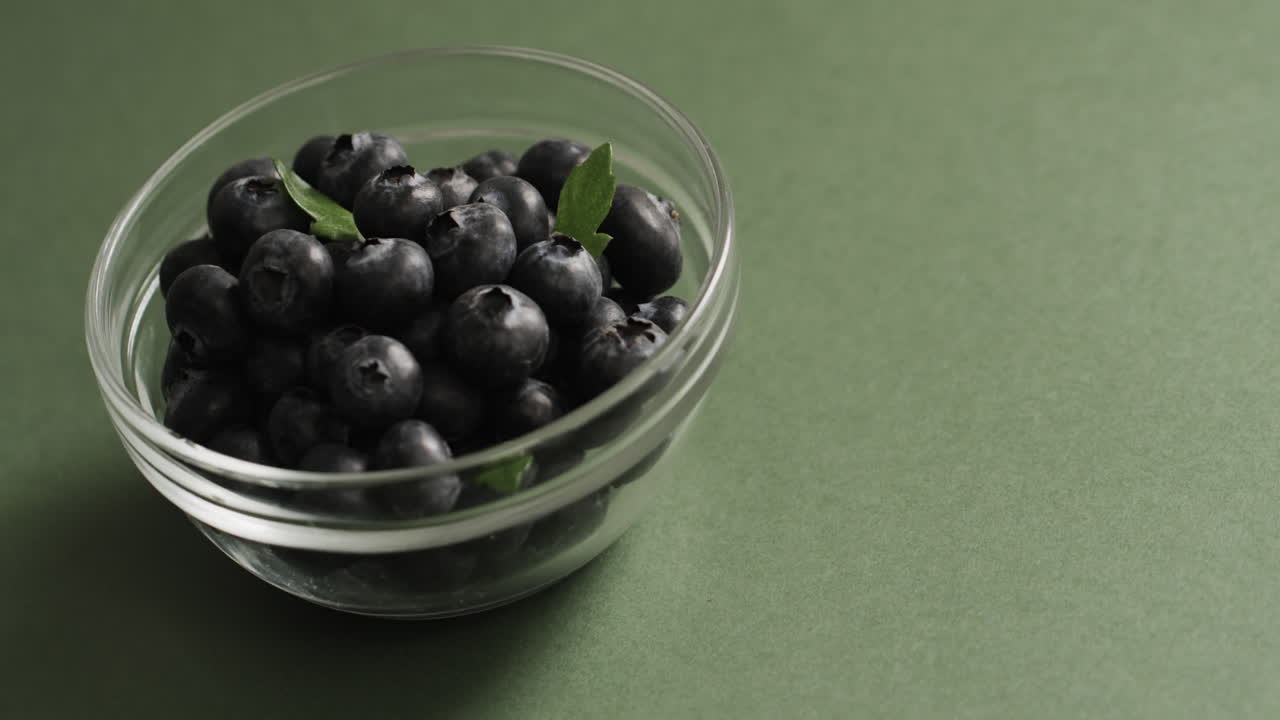 녹색 배경 에 복사 공간 을 가진 블루베리 가 있는 그 ⁇  의 클로즈업 의 마이크로 비디오
