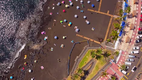 An-overhead-view-of-the-La-Arena-beachfront-of-Tenerife-in-the-Canary-Islands-with-subathers-relaxing-on-the-beach