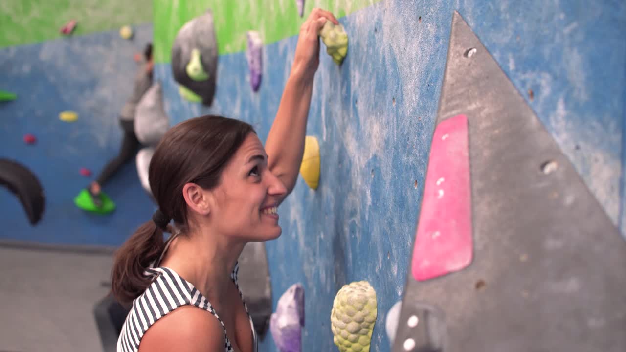 mujer escalando de forma segura en el interior de la pared de escalada