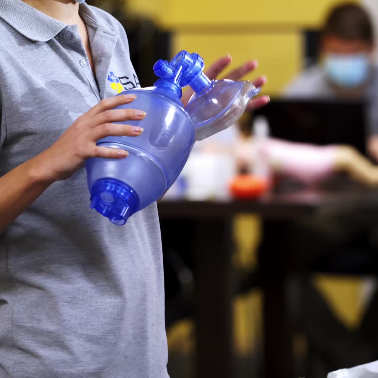 Training course for first aid. Medical worker giving instructions for saving life in resuscitation center. Dummies for demonstration on the table