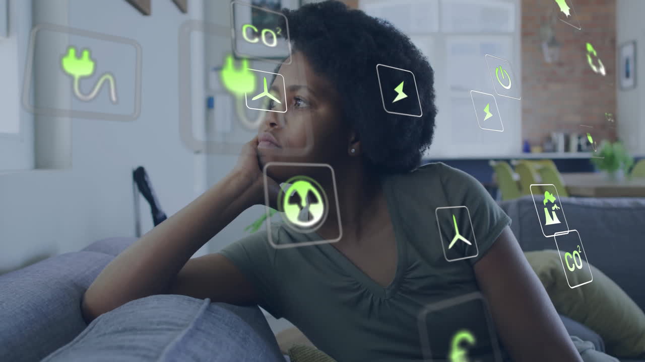 animación de iconos ecológicos y procesamiento de datos sobre mujer afroamericana en el sofá en casa