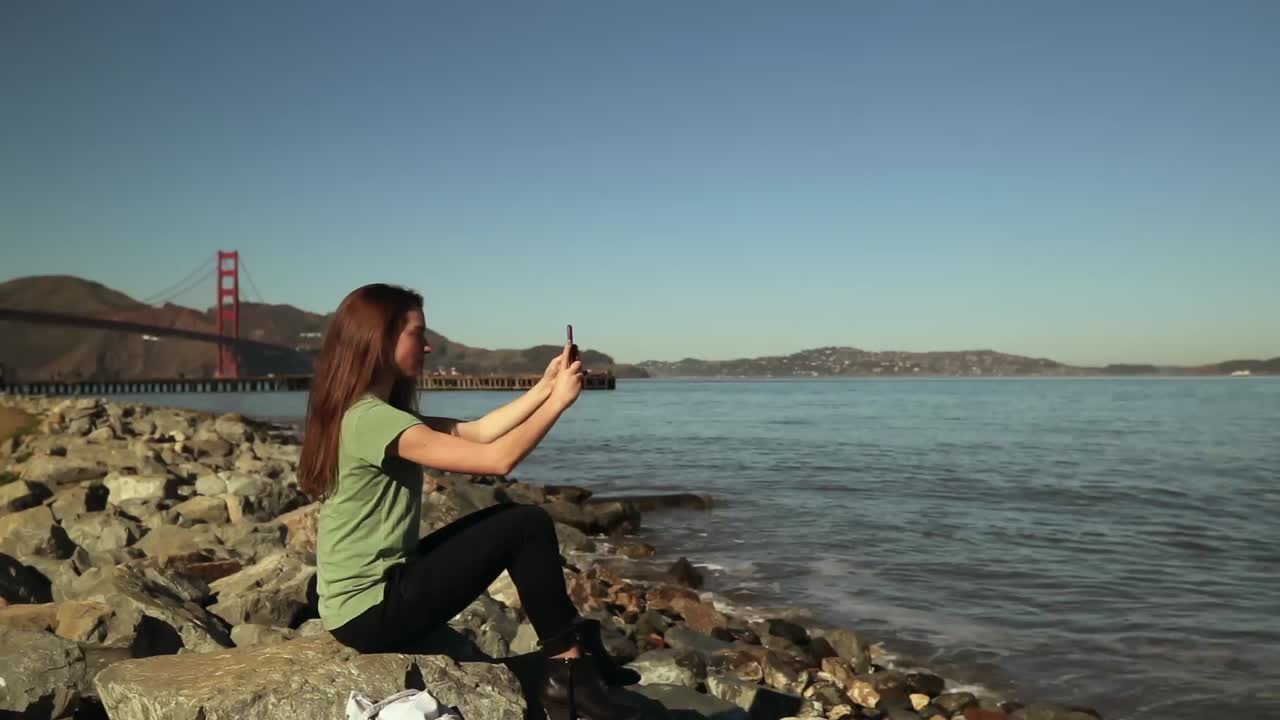mujer tomando una selfie con el puente golden gate