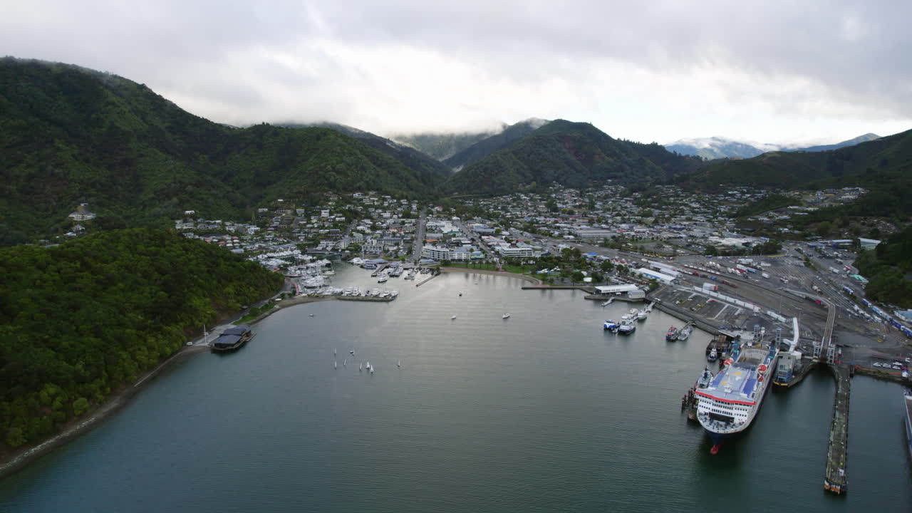 Establishing drone shot away from Picton harbour, cloudy day in New Zealand