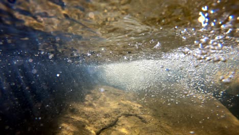 Kamera-Wird-Langsam-In-Einen-Bach-In-Sich-Schnell-Bewegendes-Wasser-Abgesenkt