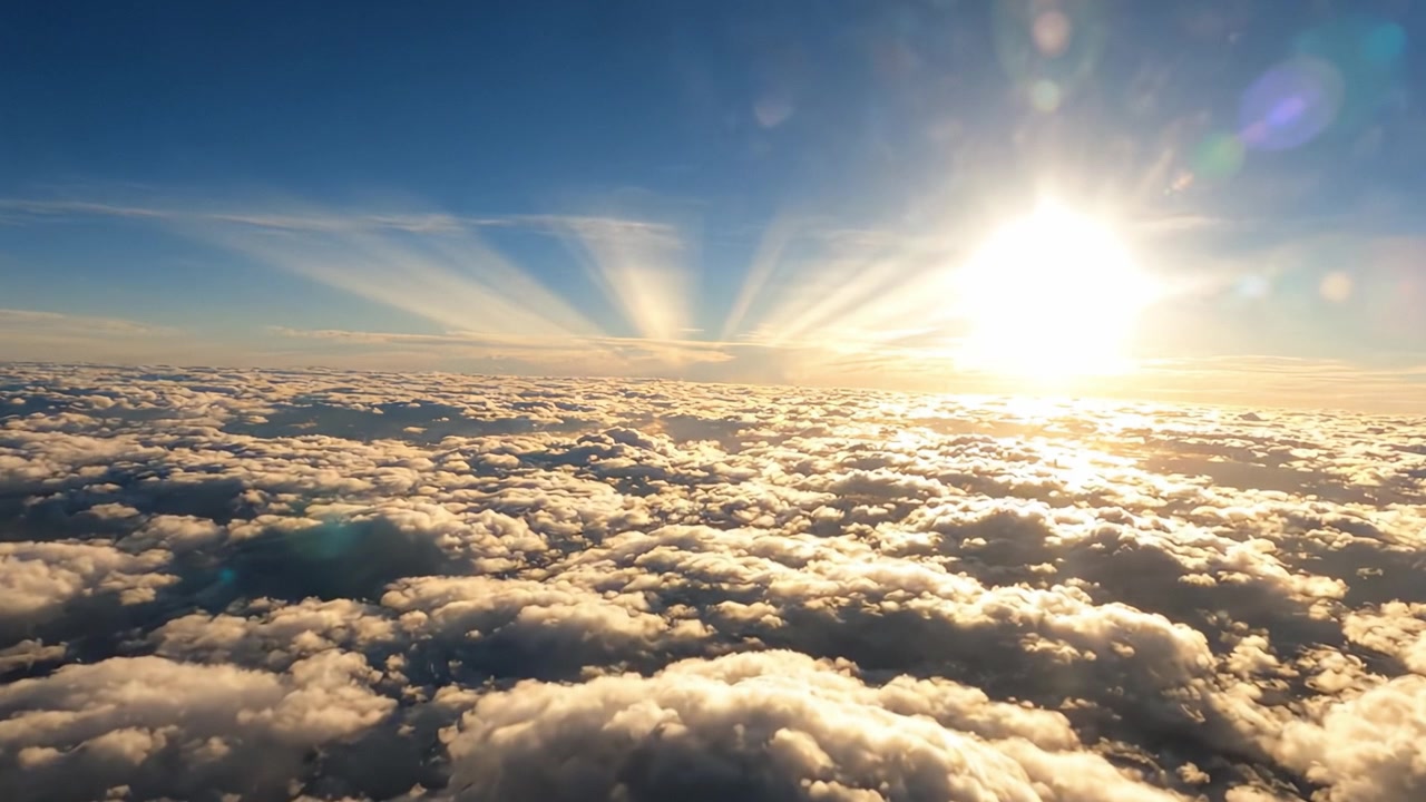 Un'alba mozzafiato su un mare di nuvole, che illumina il cielo con raggi di luce, creando un paesaggio naturale straordinario da sopra l'orizzonte.