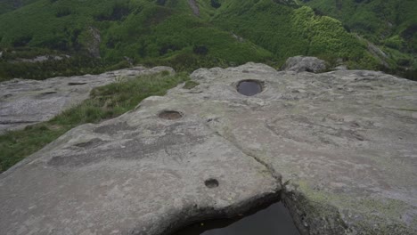 dron przechylający się nad szczytem płaskowyżu belintash, ujawniający rzeźbiony basen rytualny, położony w górach rhodope w prowincji plovdiv w bułgarii