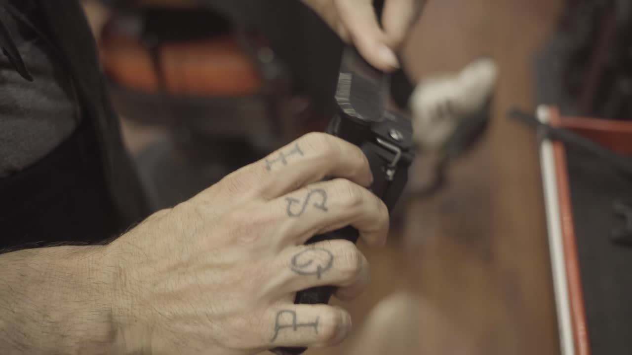 Barber's Hands Cleaning Hair Clipper With Brush At The Barber Shop