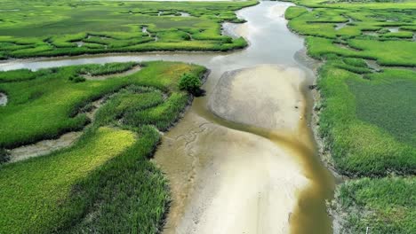 an aerial flyover of a stream creek river leading through a marsh to the matanzas river in st. augustine, florida.