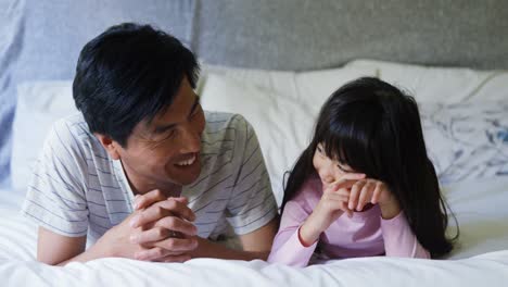 father and daughter lying together in bedroom 4k