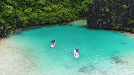 Toma-Aérea-De-Lanchas-Rápidas-Estacionadas-En-Un-Agua-De-Mar-Clara-En-Palawan-Filipinas