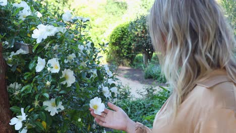 young woman coresses white flower in garden_slow motion