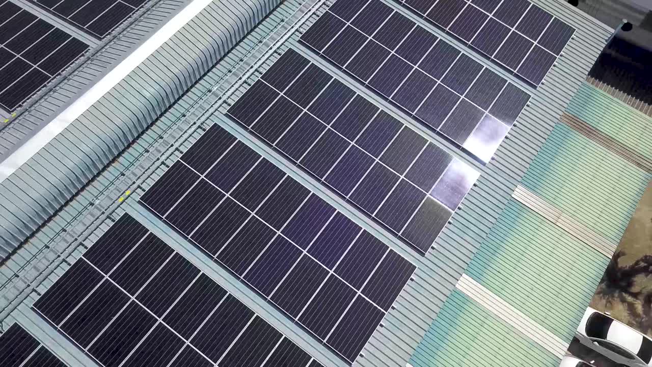 vista aérea de paneles solares a gran escala en el techo de una fábrica moderna