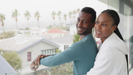smiling african american couple embracing on balcony, enjoying time together at home, copy space