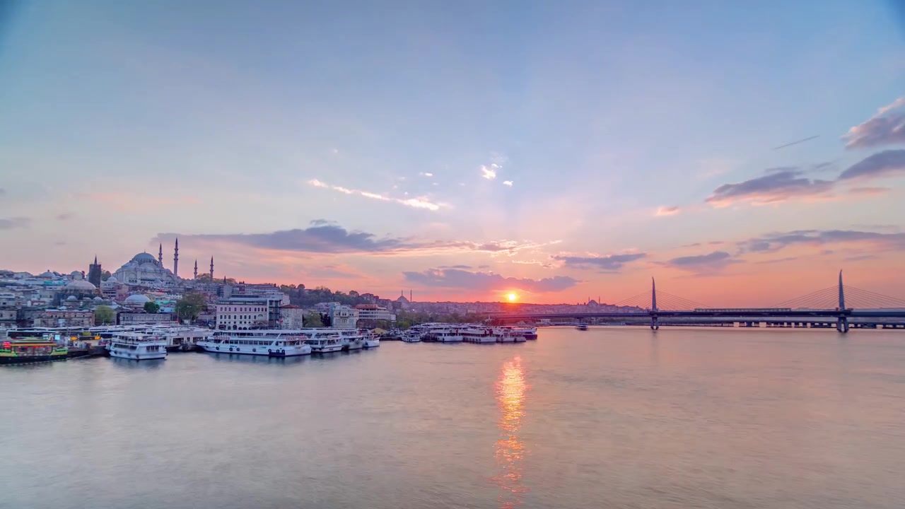 Passagierfähren nahe der Fähranlegestelle im Goldenen Horn nahe dem Bosporus bei Sonnenuntergang Zeitraffer, Istanbuler Skyline, Türkei. Moschee und Brücke im Hintergrund mit Spiegelung auf dem Wasser an einem Frühlingstag