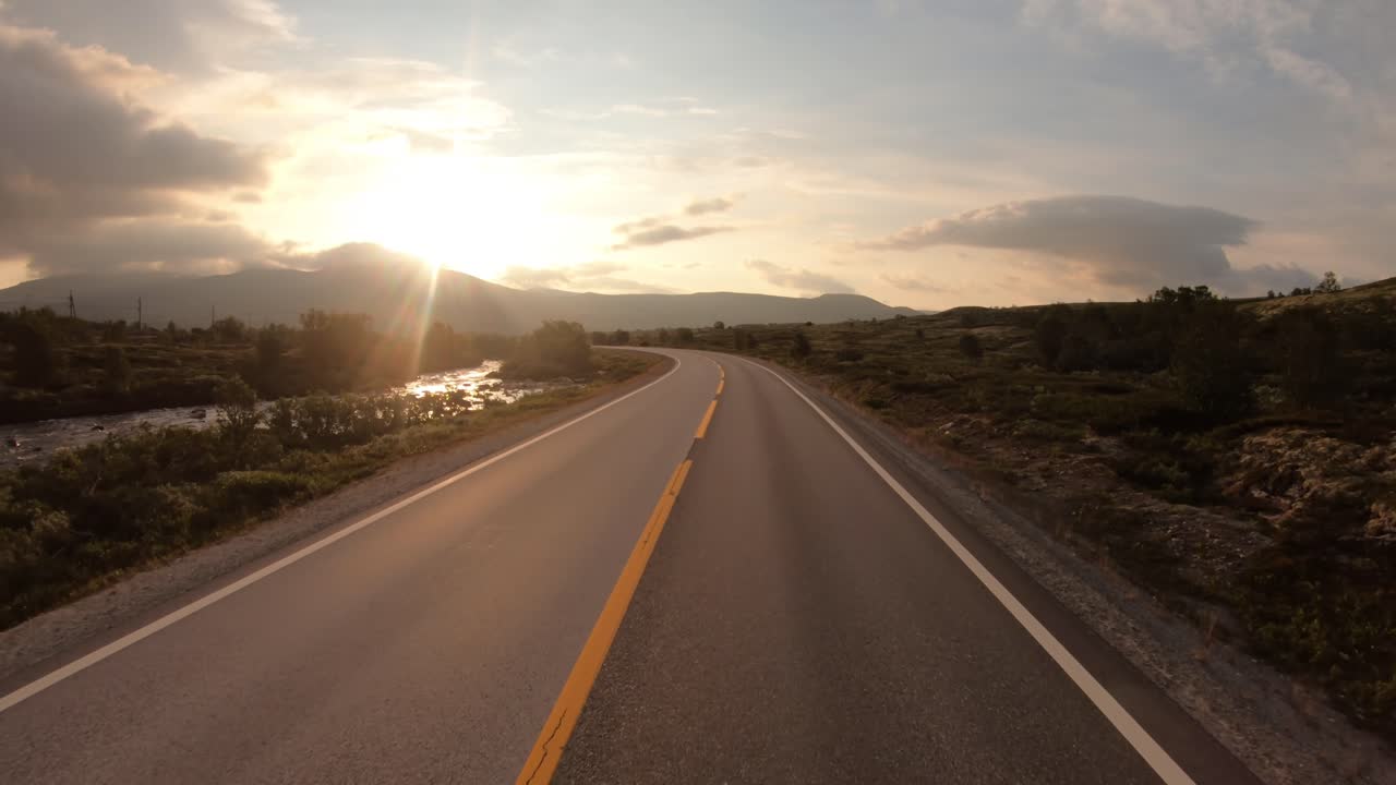 conduciendo un coche por una carretera en noruega al amanecer