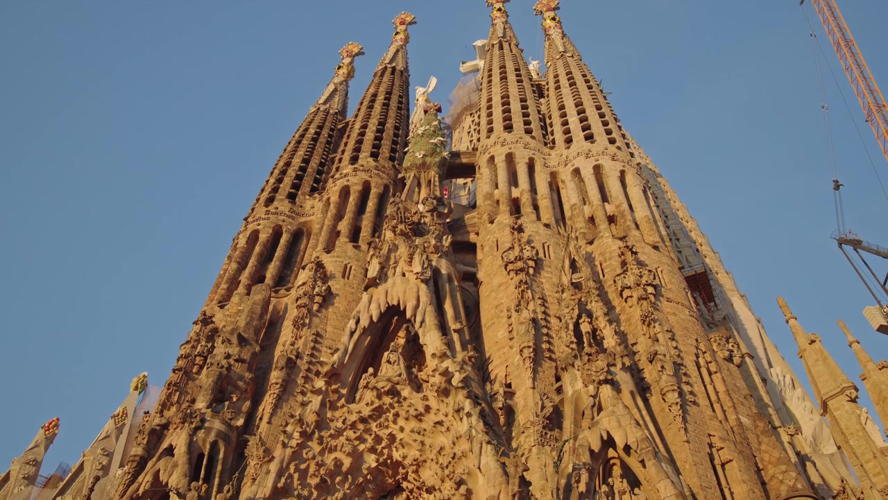Facciata della basilica della Sagrada Familia con dettagliata architettura gotica a Barcellona al tramonto