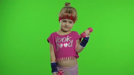 chica caucásica en ropa deportiva haciendo ejercicios con pesas. entrenamiento para niños. niño atlético