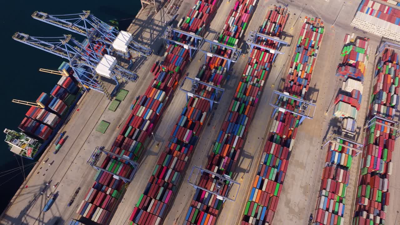 Luftfoto af fragtplads med kraner og containerstabler.