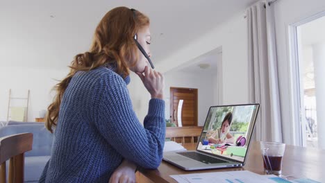 caucasian female teacher using laptop and phone headset on video call with schoolgirl