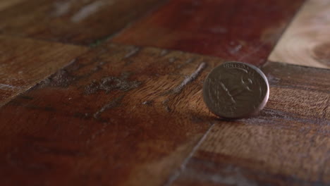 moneda de un cuarto de dólar gira en el suelo de madera