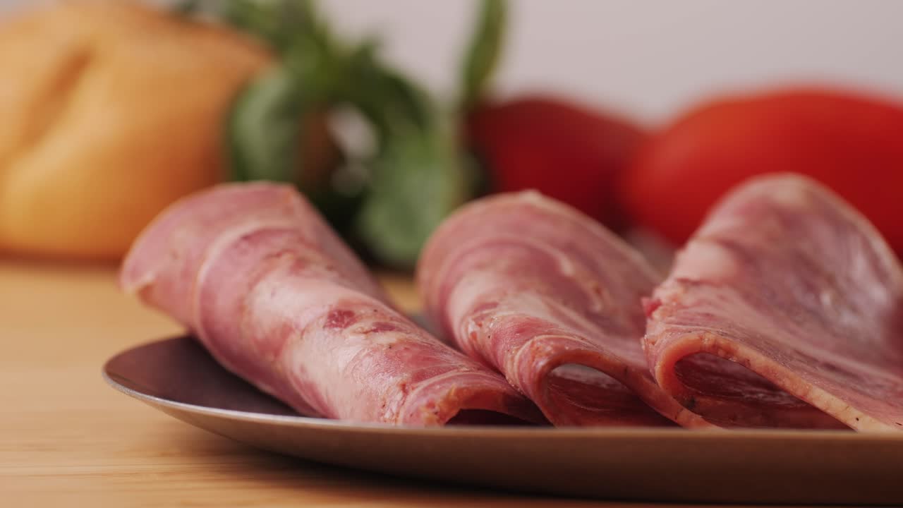 black bull sausage ham, tongue pork dry-cured sausage on a black background, traditional spanish delicatessen food, close up.