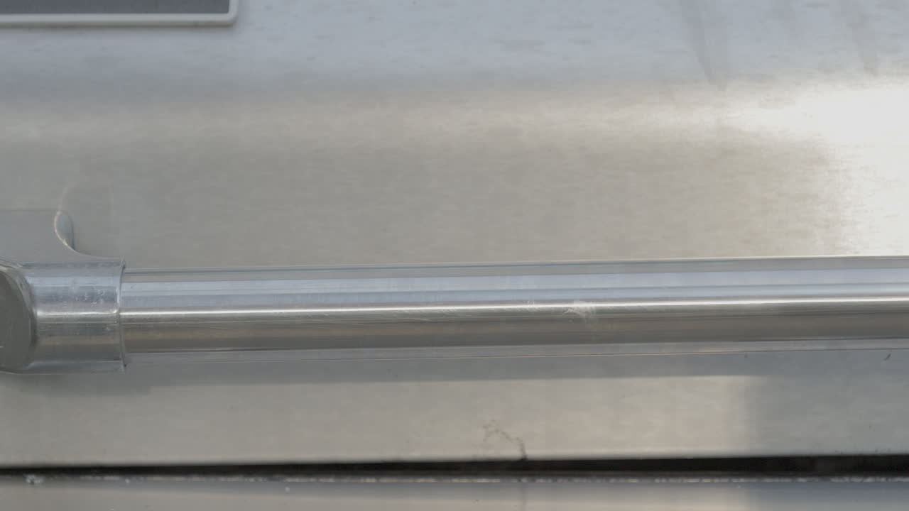 крышка газового гриля открывается, чтобы показать свежие стейки, готовящиеся на гриле, а затем закрывается, крупный план