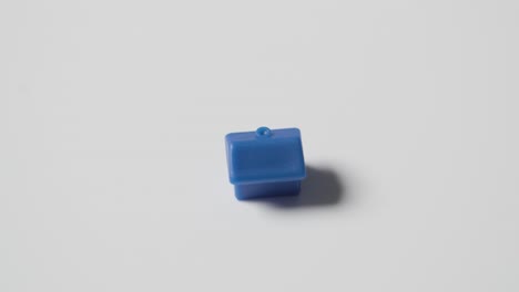 home buying concept with blue plastic model of house revolving on white background