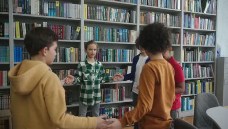 niños multinacionales juegan un juego entretenido en la biblioteca