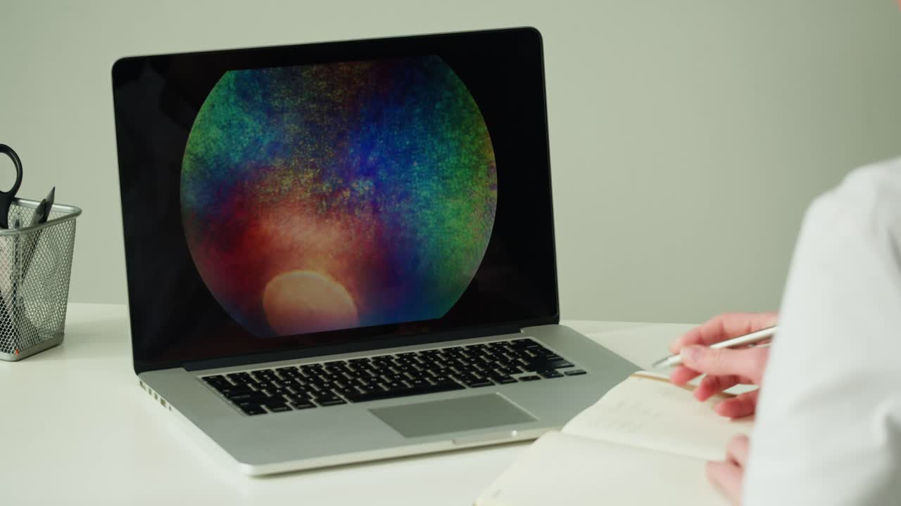 Person working on a laptop with microscope image